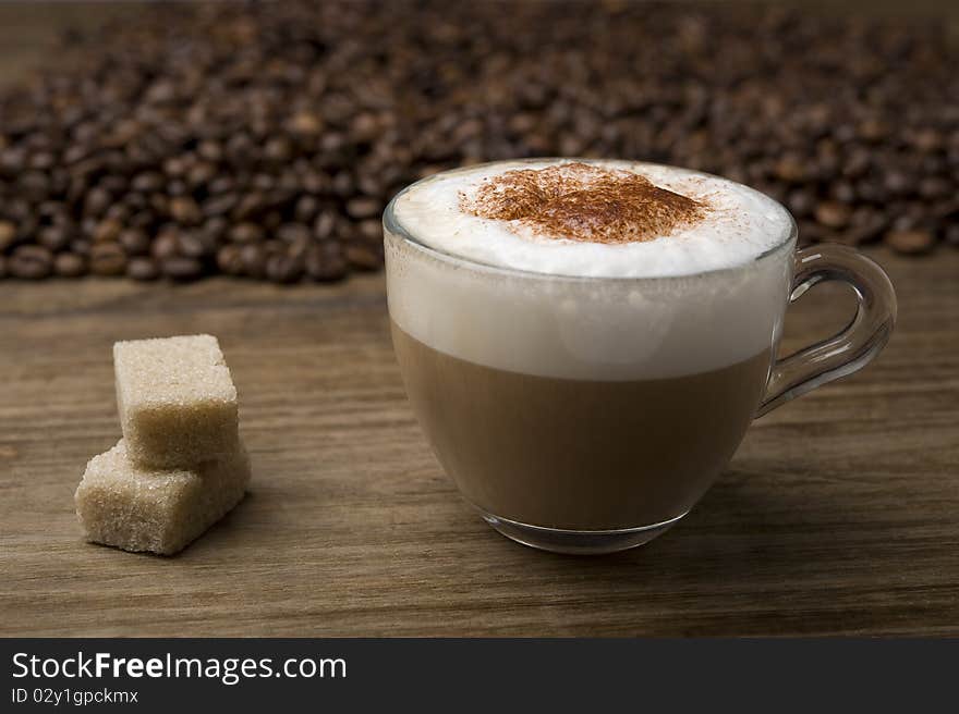 Cup of cappuccino on coffee beans background