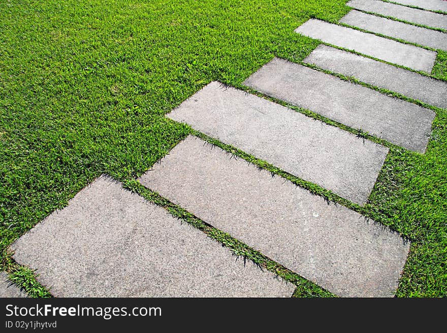 Detail of a pavement path going through the grass. Detail of a pavement path going through the grass