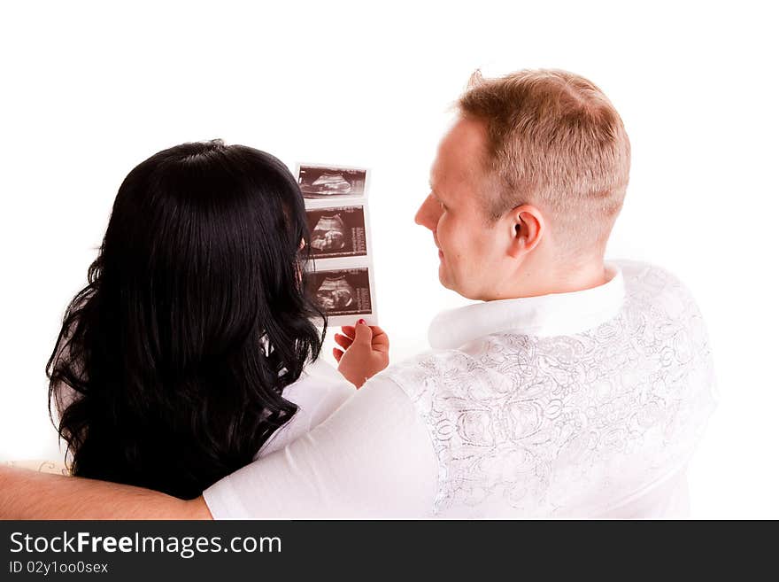 Beautiful young couple holding a sonogram of their unborn child