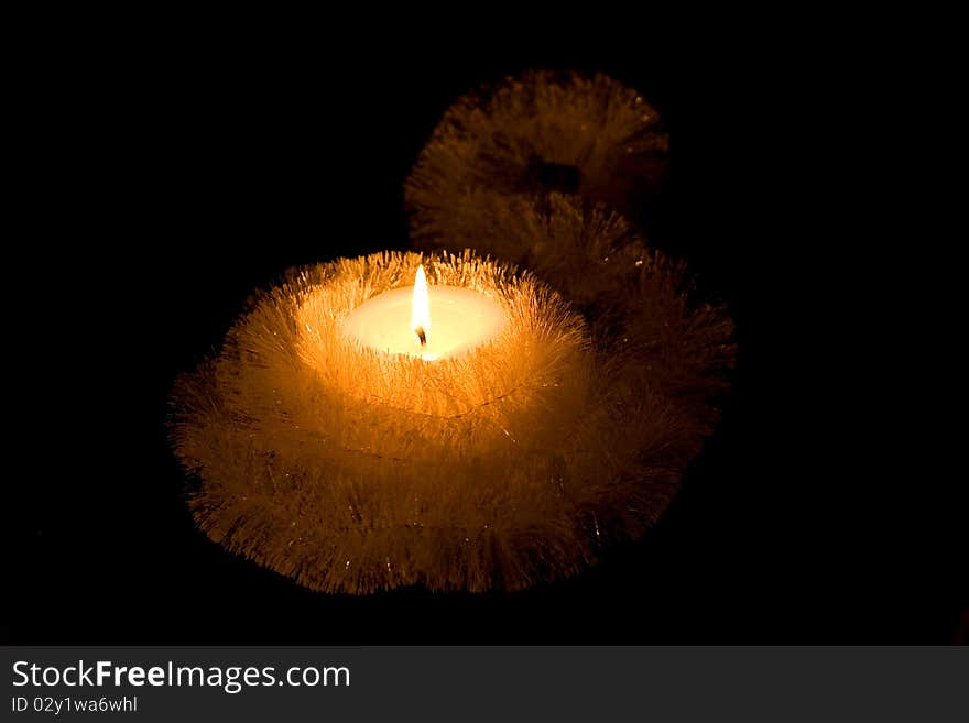 Christmas Candle. Small candle with bright glowing flames on a black background. Christmas Candle. Small candle with bright glowing flames on a black background.