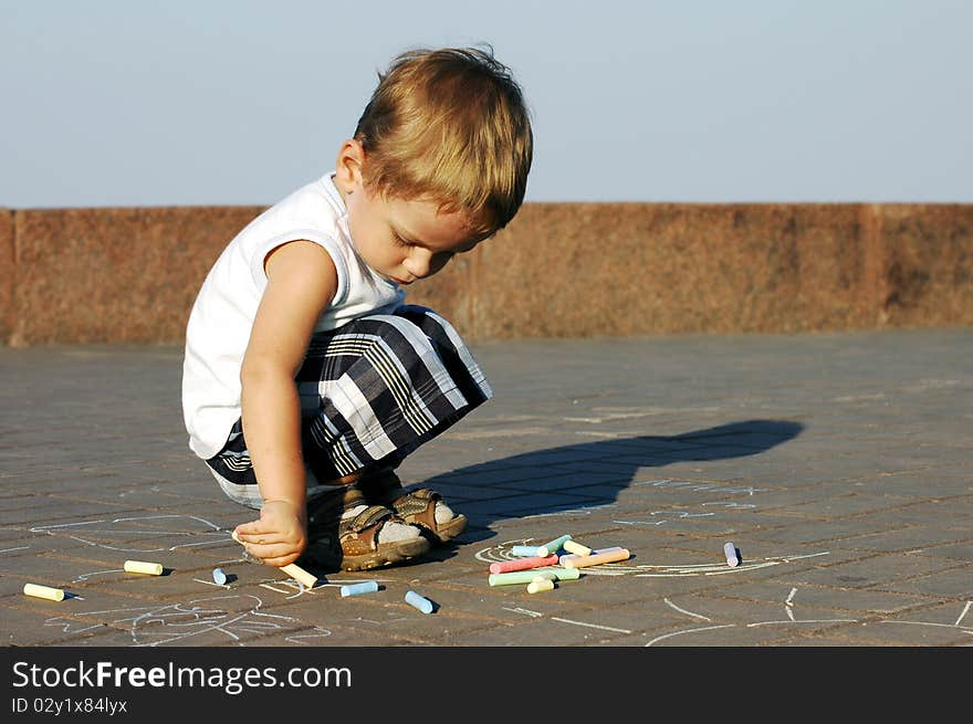 Child in the park draws with chalk. Child in the park draws with chalk