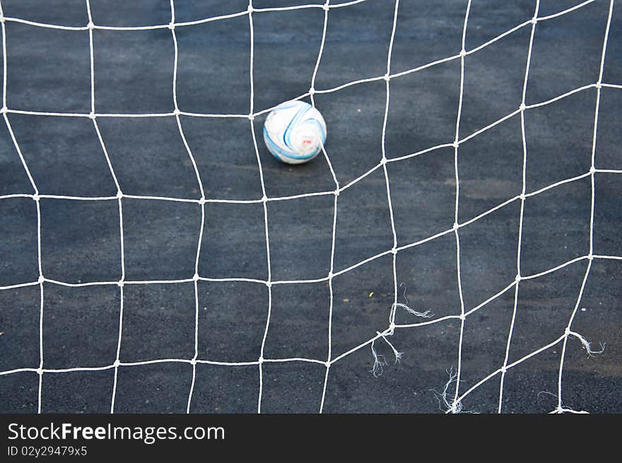 Goal net and football in the park