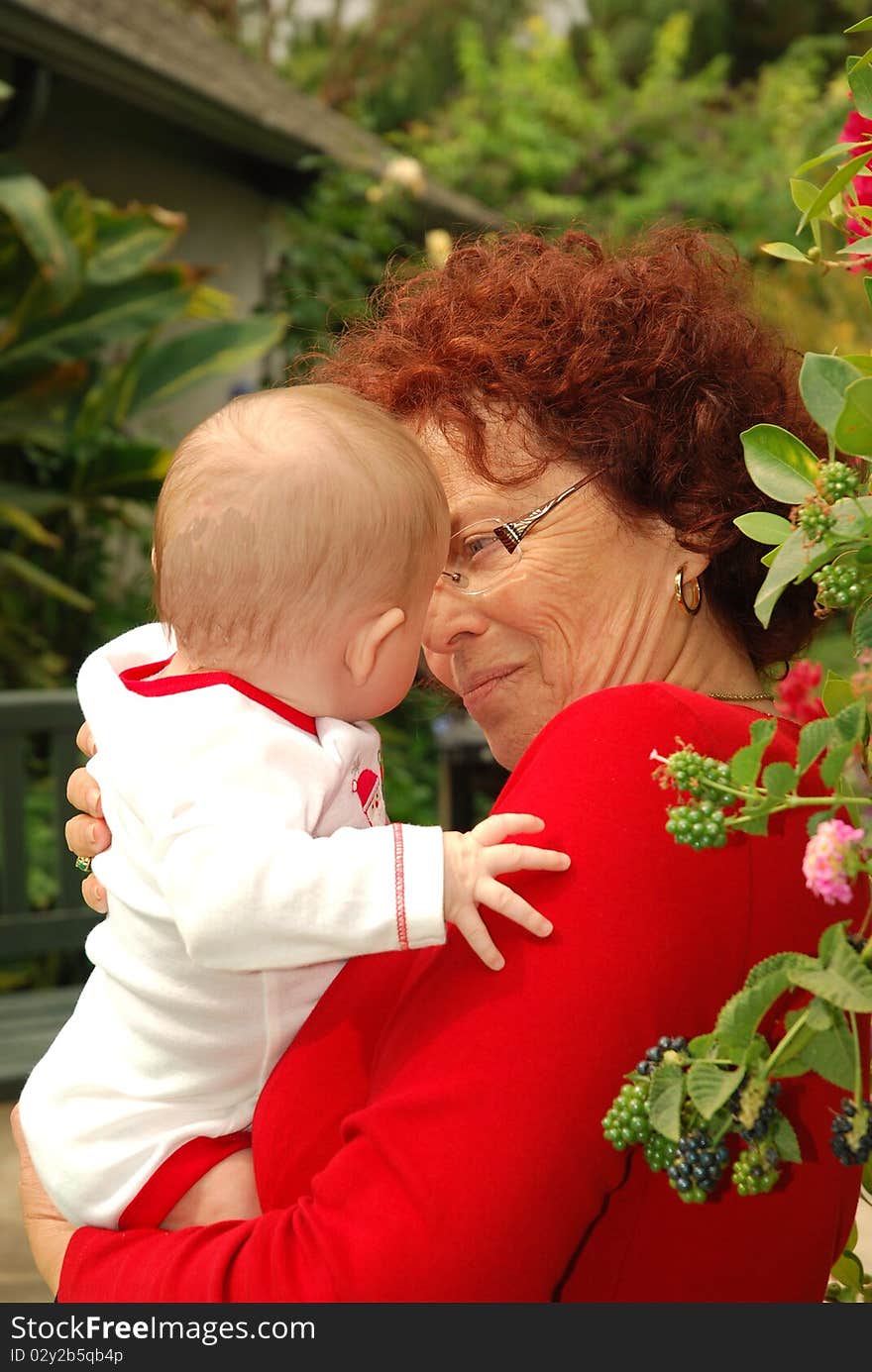 A Grandmother In Striking Red With Her Grandbaby