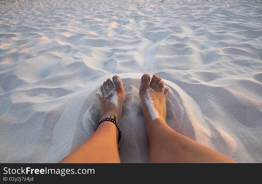 Feet playing in the sand on a white sand beach. Feet playing in the sand on a white sand beach