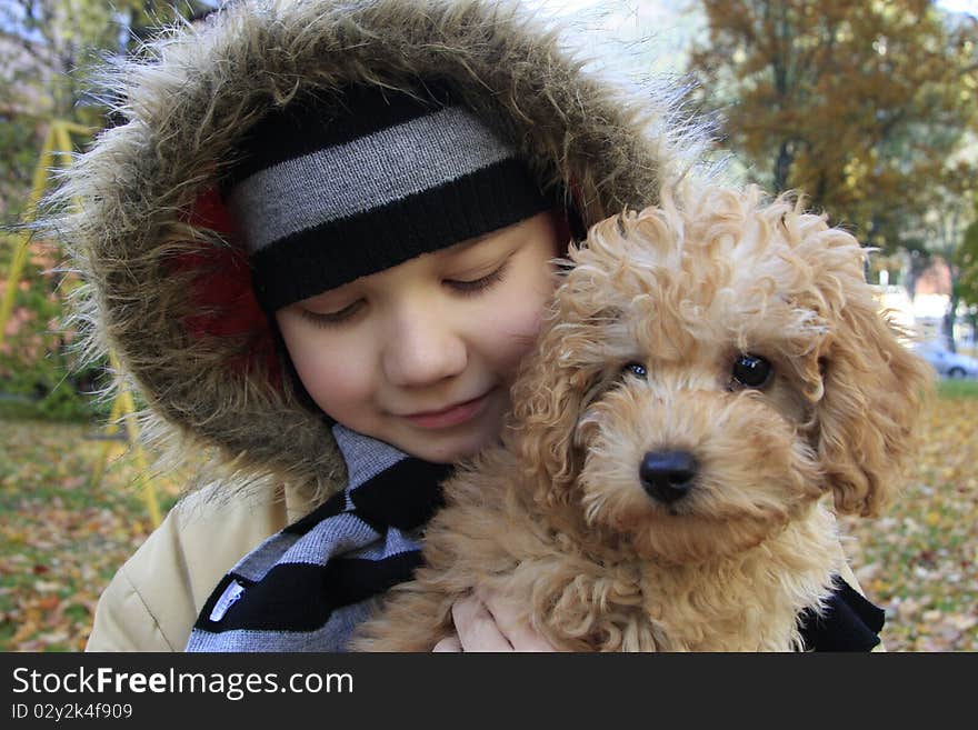 Just out from house, small boy with small dog, two good friends. In autumn and very cold day. Just out from house, small boy with small dog, two good friends. In autumn and very cold day.