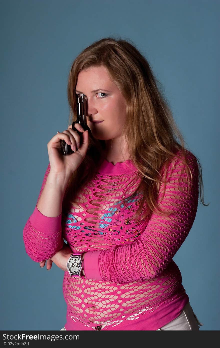 Cute young girl with gun in studio