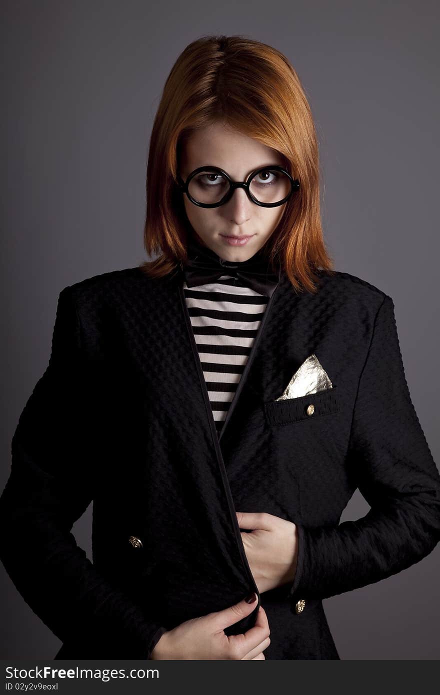 Portrait of fashion girl in jacket and glasses. Studio shot.