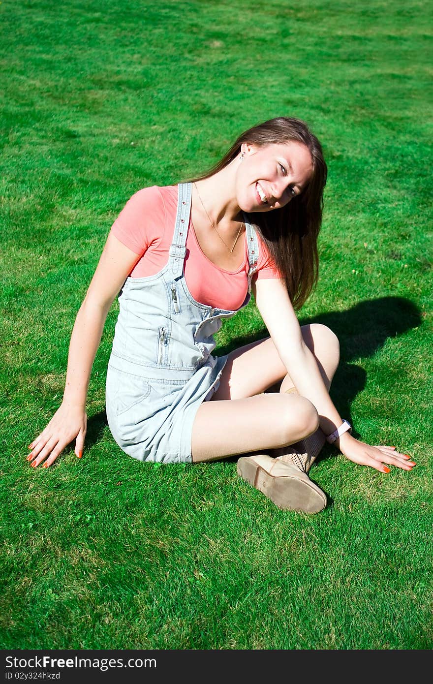 Cute brunette on the green grass in summer. Cute brunette on the green grass in summer