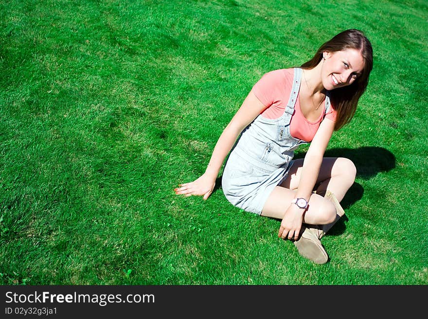 Cute Brunette On The Green Grass In Summer