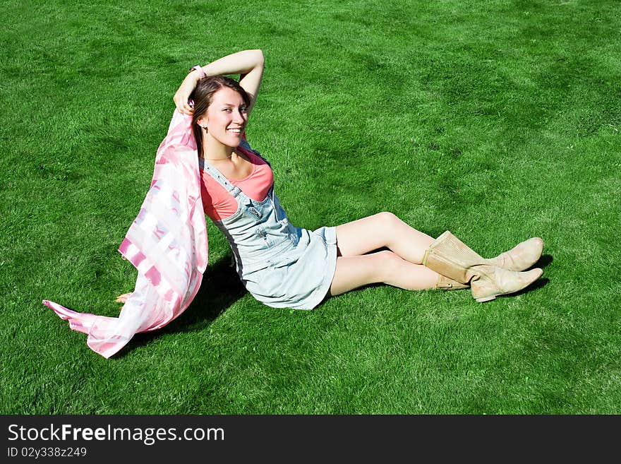 Happy young brunette on the green grass. Happy young brunette on the green grass