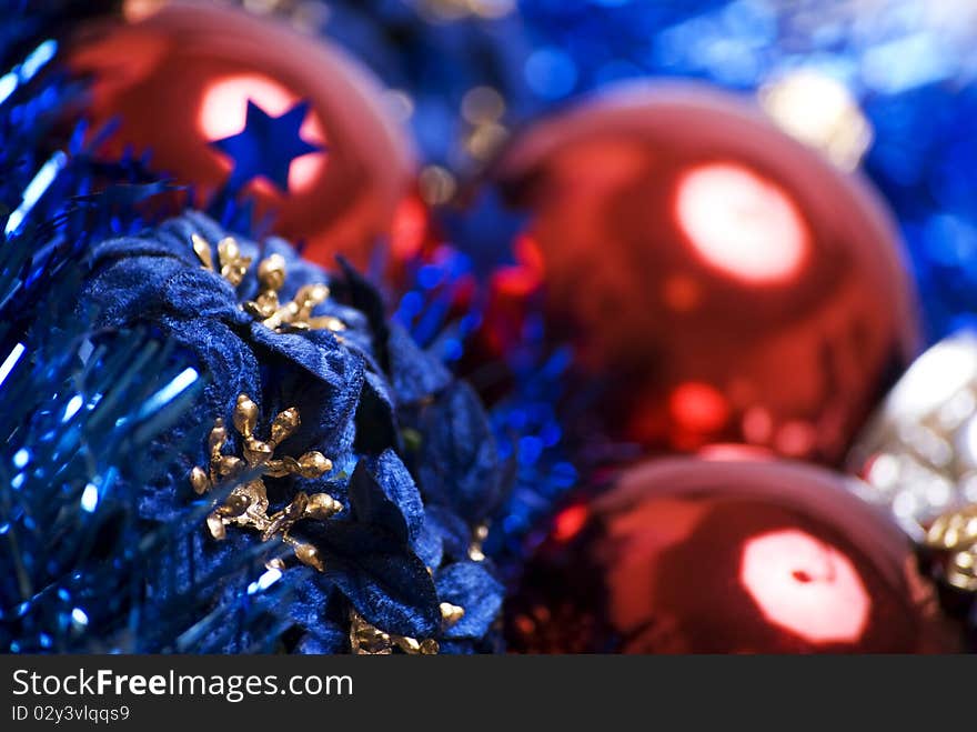 Red Christmas ball with blue decorative flowers and tinsel close-up. Red Christmas ball with blue decorative flowers and tinsel close-up