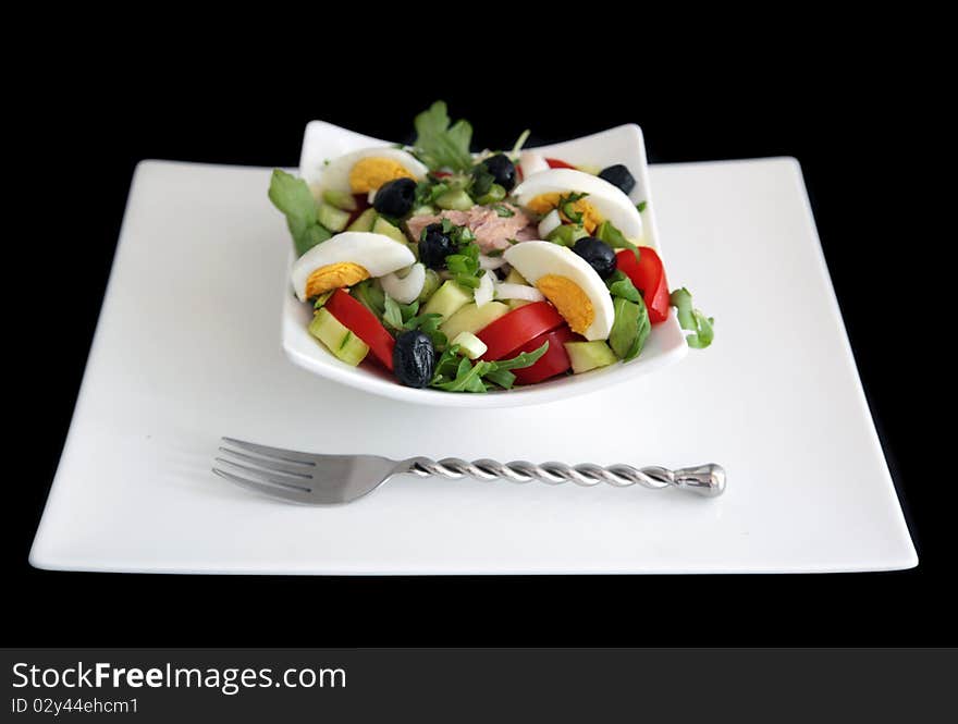 Niçoise salad (without the anchioves & peppers) on white plate shot on black background. Niçoise salad (without the anchioves & peppers) on white plate shot on black background.