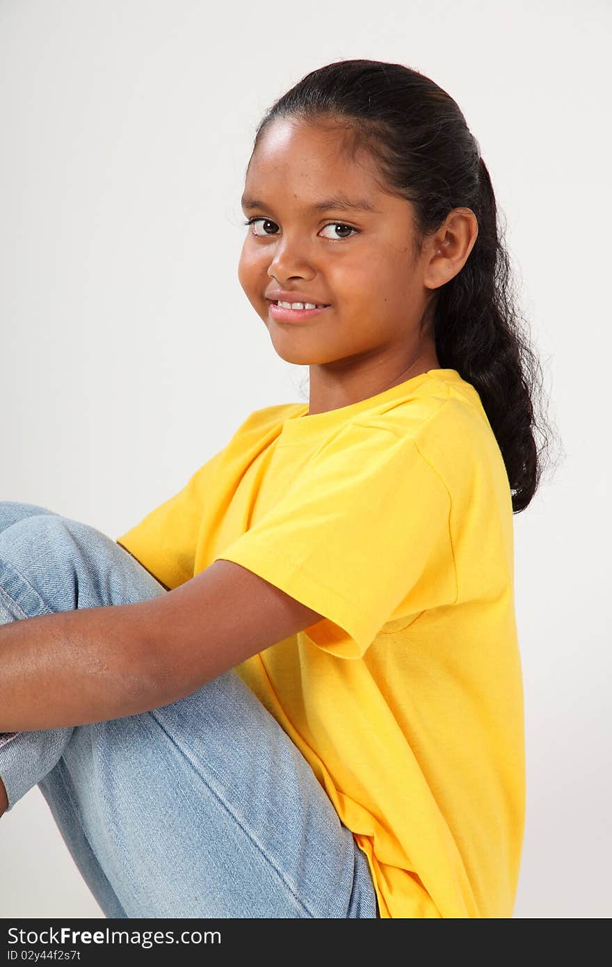 Close up portrait of happy young ethnic school girl, 9, giving pretty smile straight at camera. Studio shot against white background - Canon 5D MKII. Close up portrait of happy young ethnic school girl, 9, giving pretty smile straight at camera. Studio shot against white background - Canon 5D MKII