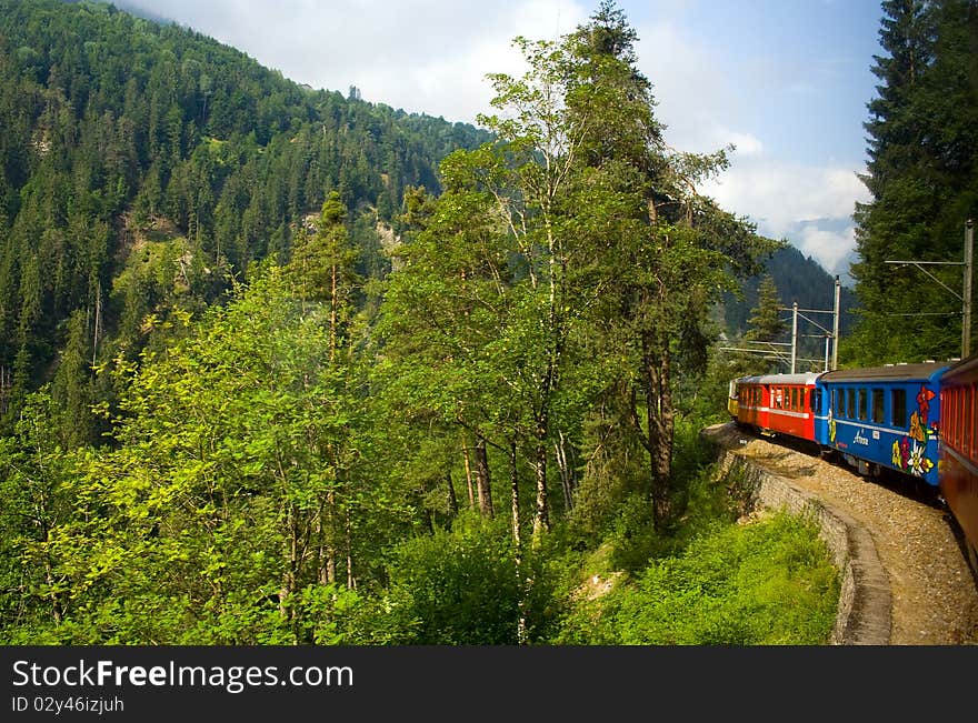 View of a train passing through the Swiss countryside. View of a train passing through the Swiss countryside