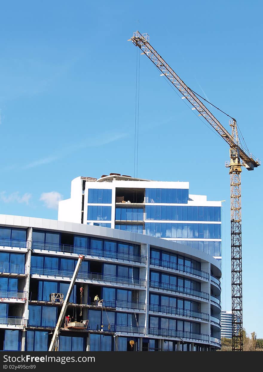 Building of the house with the crane against the dark blue sky. Building of the house with the crane against the dark blue sky