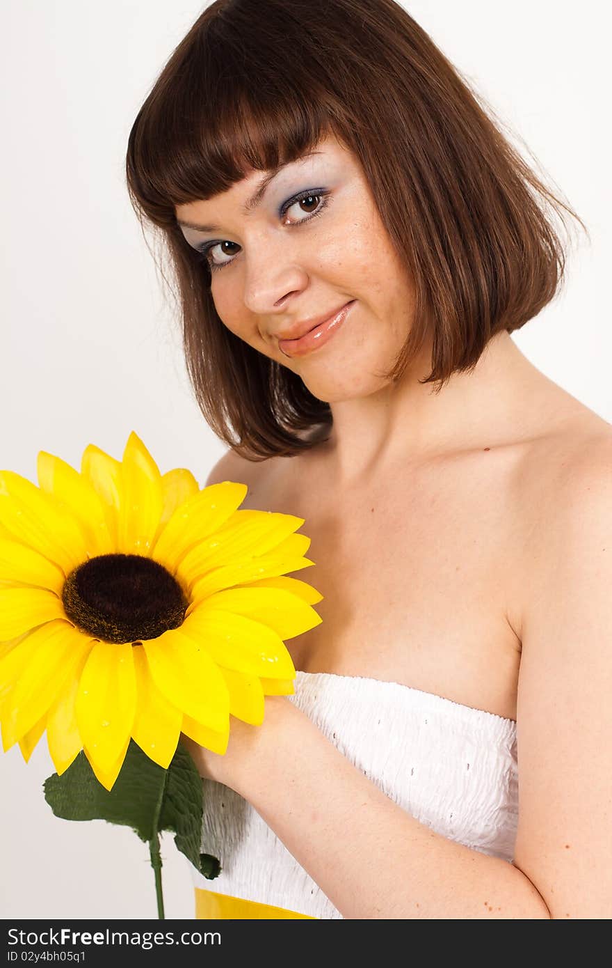 Beautiful girl smiling and holding a sunflower - isolated over a white background. Beautiful girl smiling and holding a sunflower - isolated over a white background