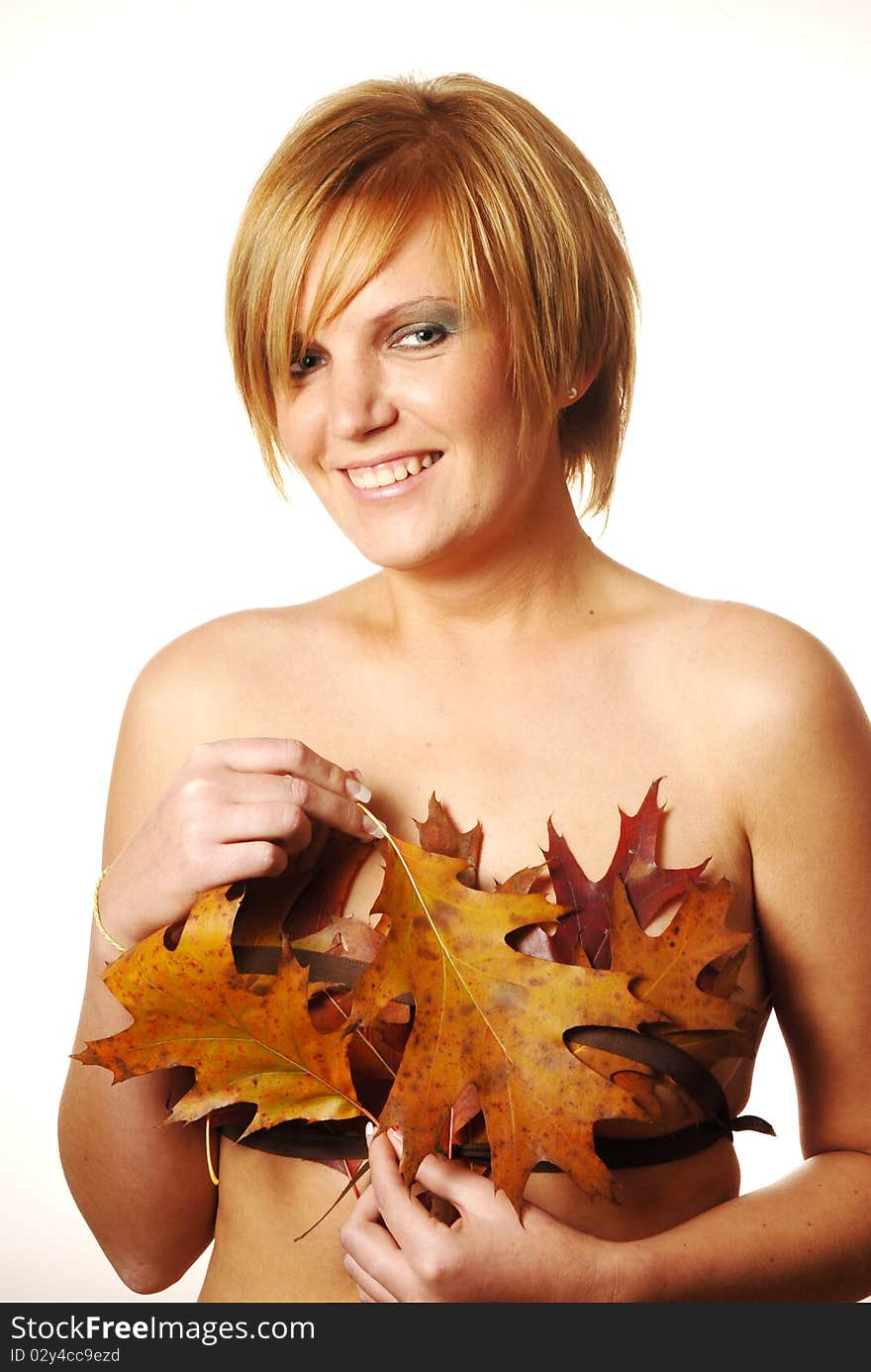 Young woman having fun at the autumn leaves