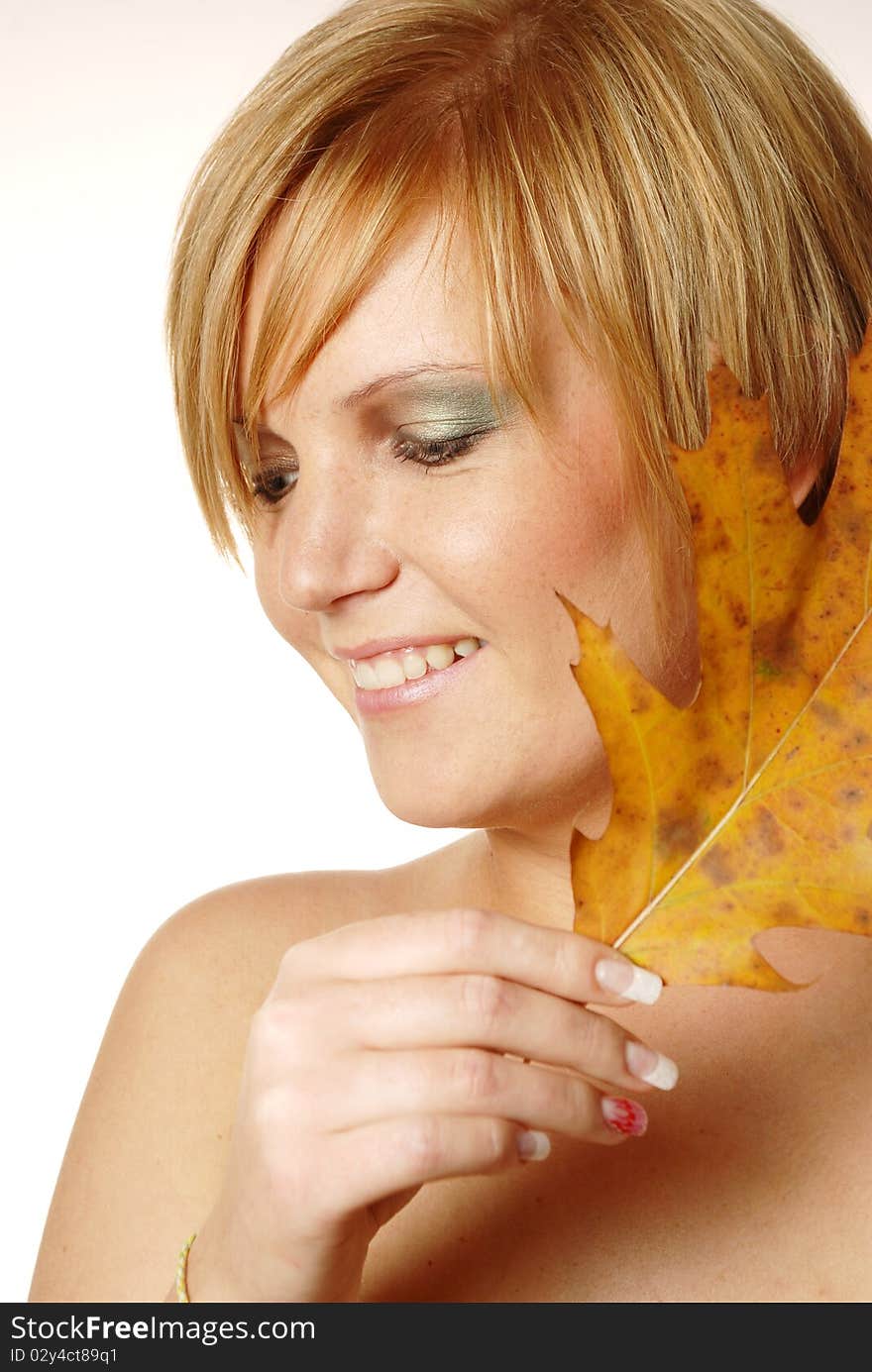 Young woman having fun at the autumn leaves