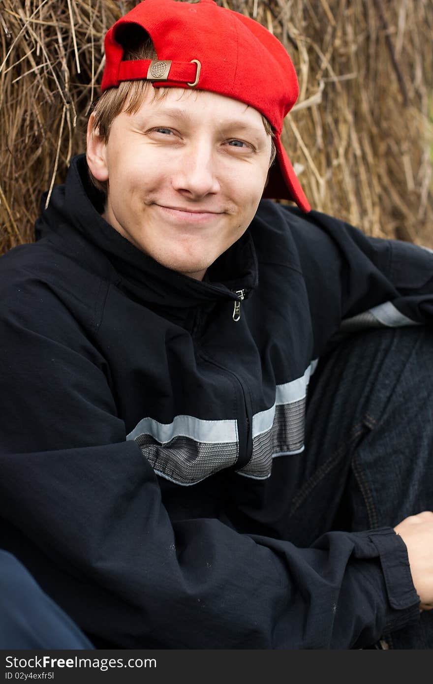 Boy in a stylish red cap resting in a field. Boy in a stylish red cap resting in a field