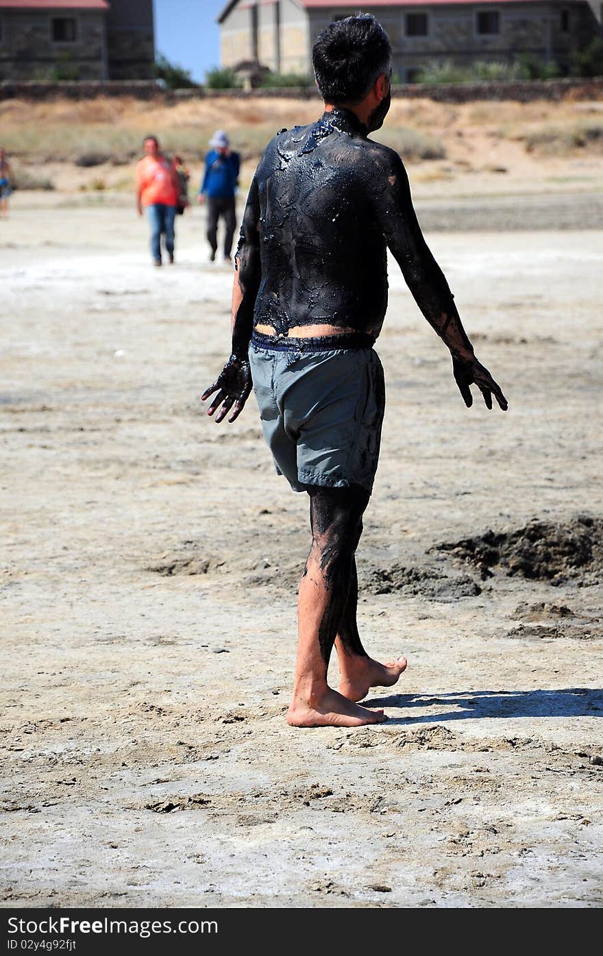 man covered with mud for mudbath