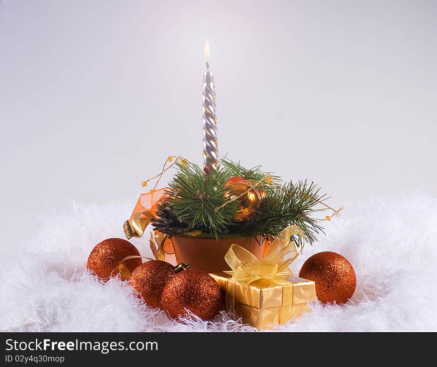 Christmas orange spheres and silver candles on the white fur