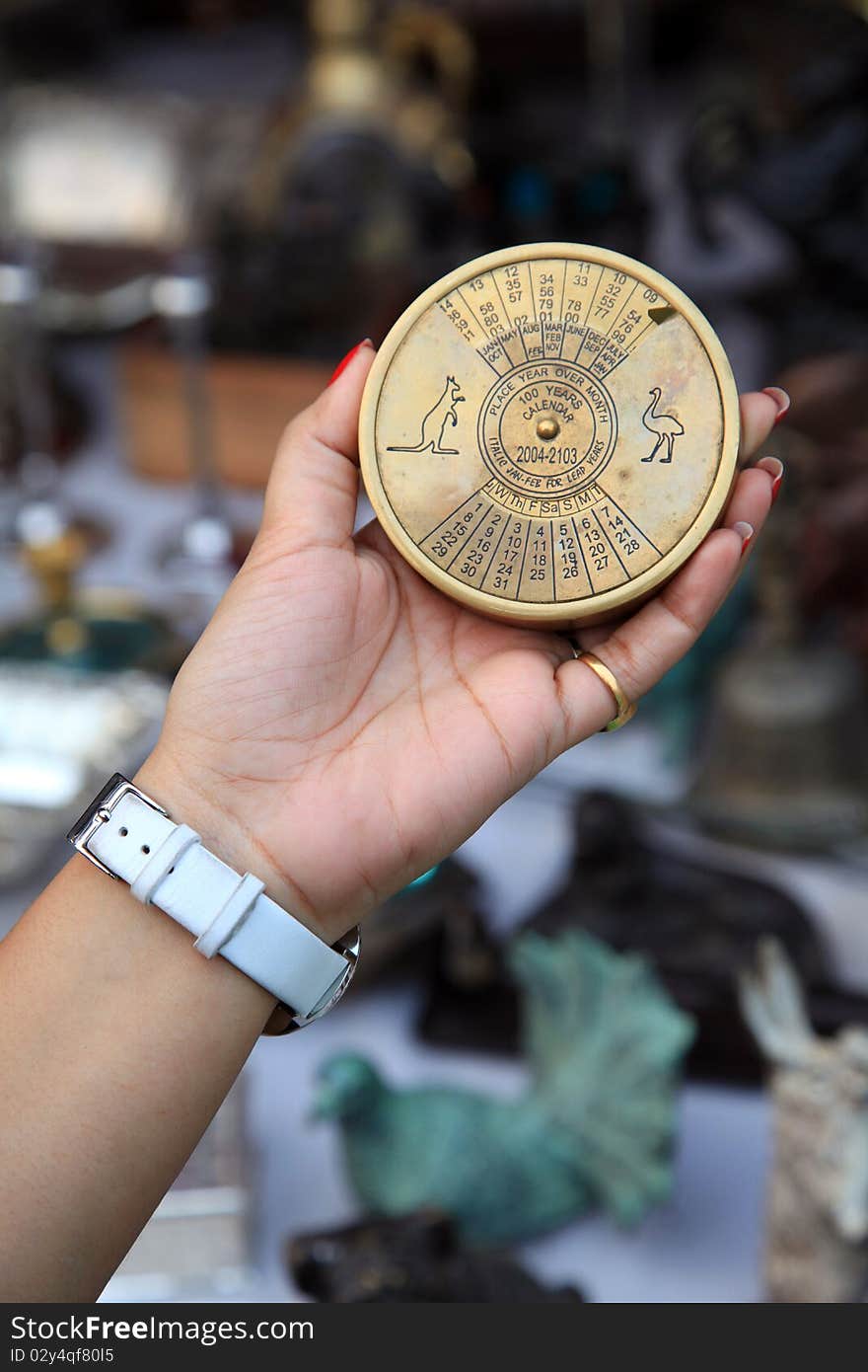 Female hand holding ancient vintage calender device.