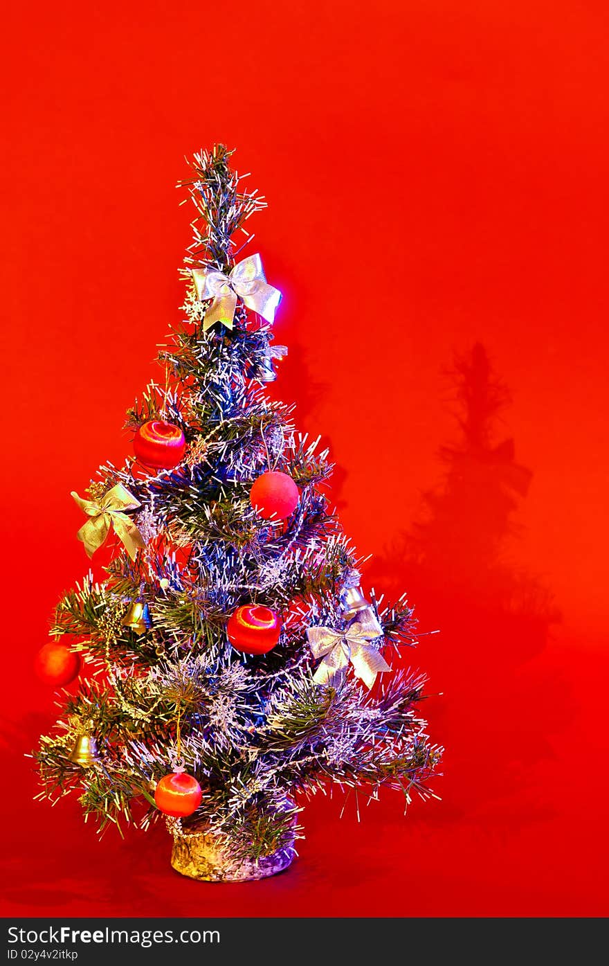 Christmas tree is richly decorated with a red background