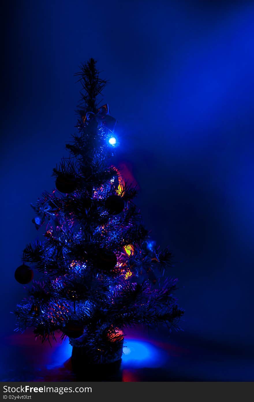 Christmas tree is richly decorated with a blue background