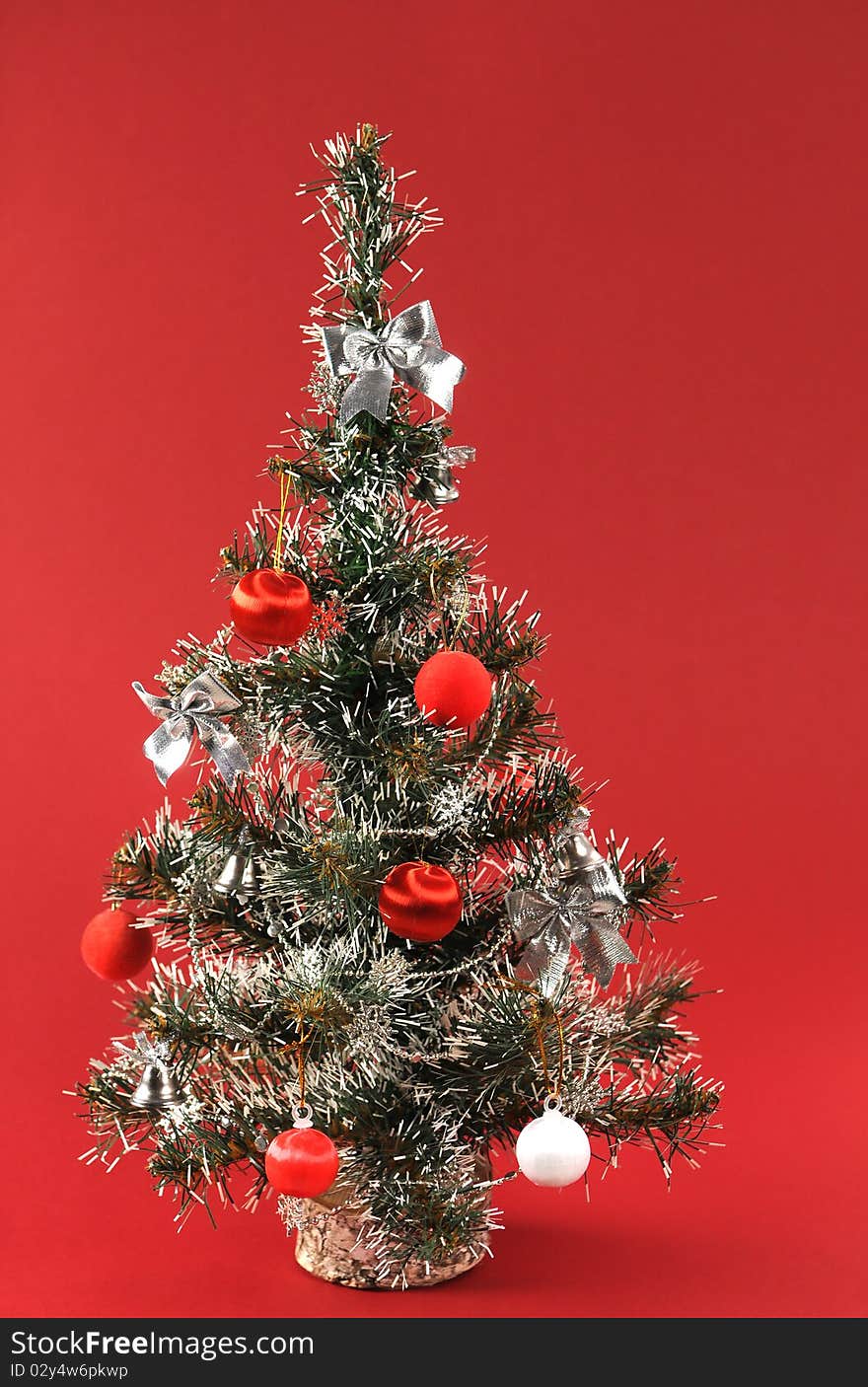 Christmas tree is richly decorated with a red background