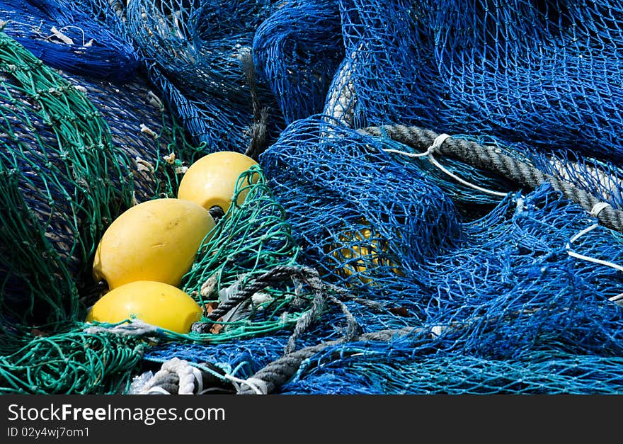 Close-up of blue and emerald green fishing nets and yellow floats. Close-up of blue and emerald green fishing nets and yellow floats