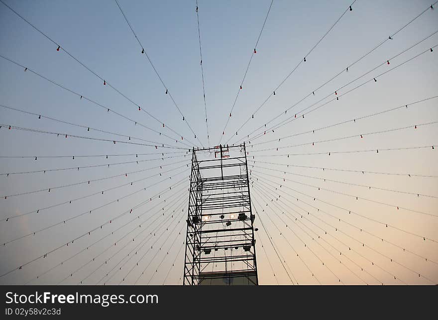 Light bulbs hanging on wires from tower, looking like a huge web. Light bulbs hanging on wires from tower, looking like a huge web.