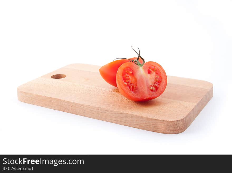 Two part of tomato on brown kitchen board. Horizontal image