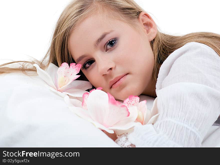 Portrait of a lying girl with long blond hair with white orchids. Portrait of a lying girl with long blond hair with white orchids.