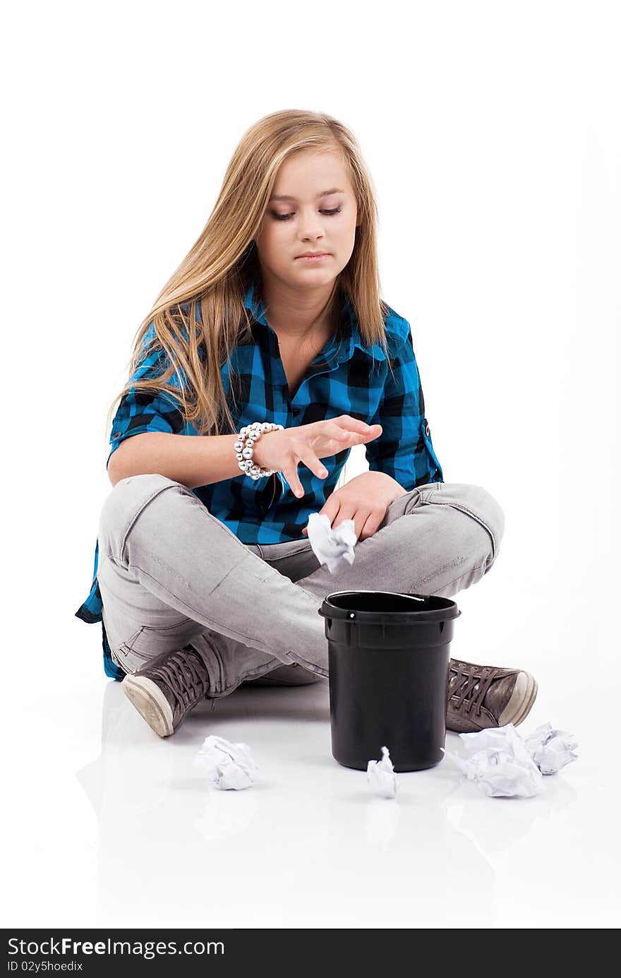 Teenage girl is sitting and throwing rubbish into the garbage. Teenage girl is sitting and throwing rubbish into the garbage.