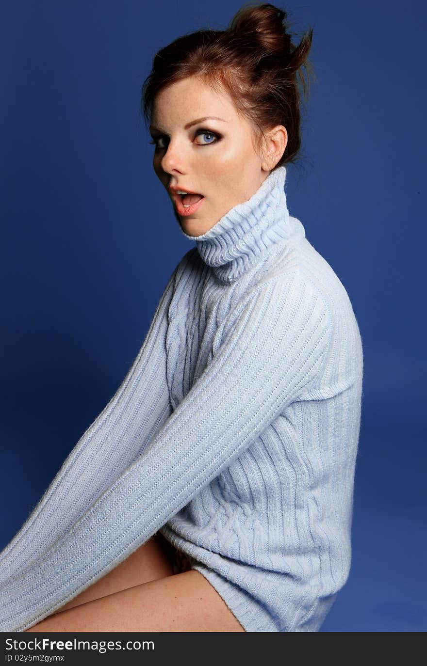 Sitting young woman in a blue sweater