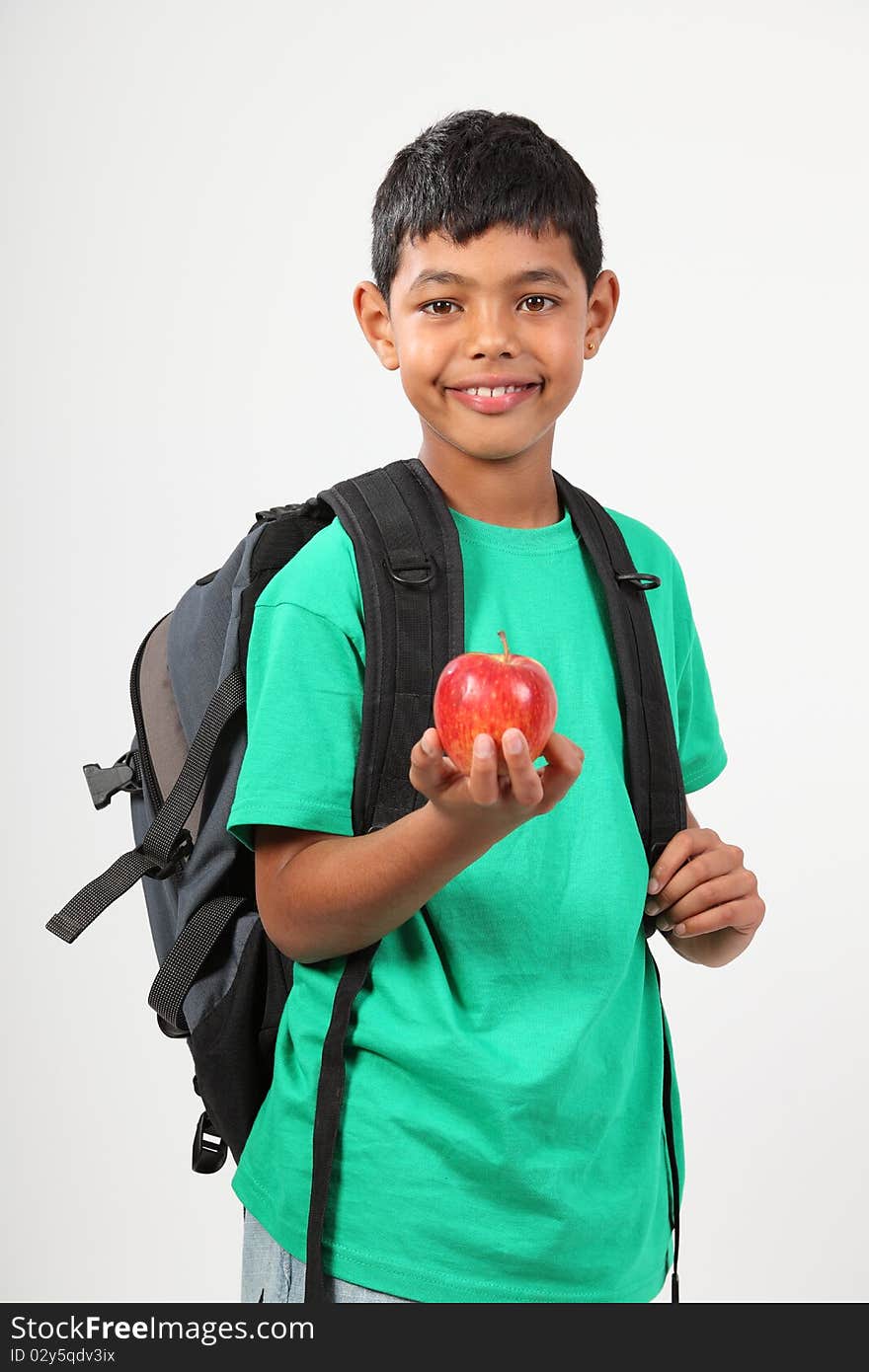 Cheerful school boy 10 smiling holding red apple