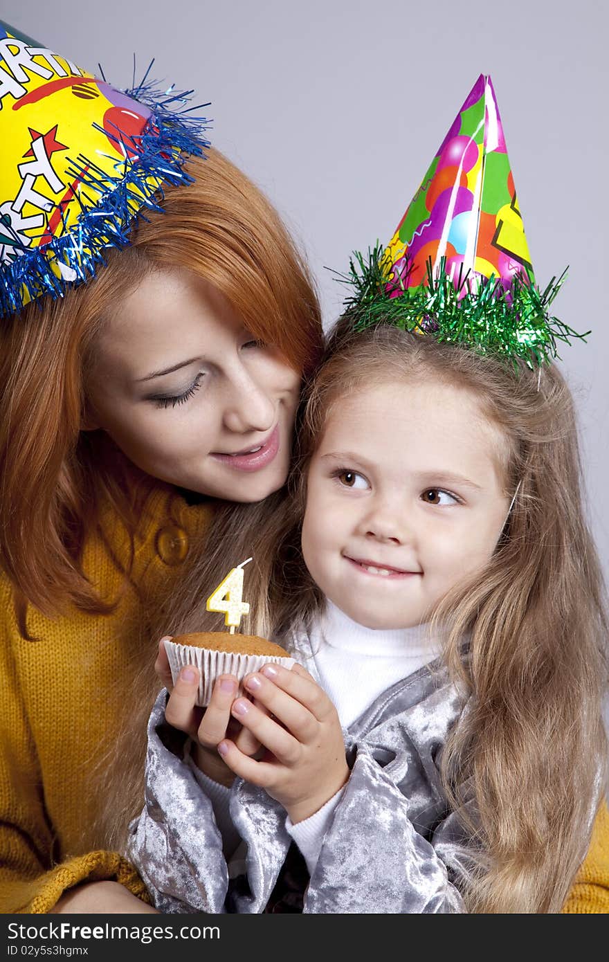 Two sisters four and eighteen years old at birthday. Studio shot.