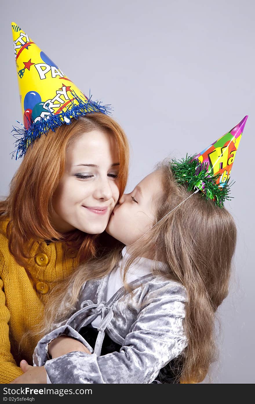 Two sisters four and eighteen years old at birthday. Studio shot.