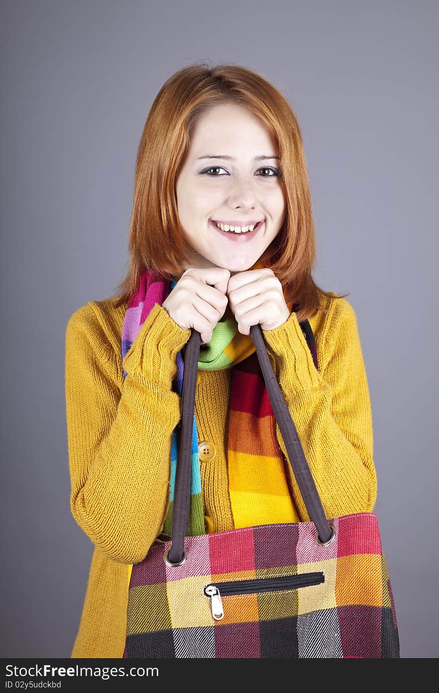 Portrait of red-haired girl in scarf. Studio shot.