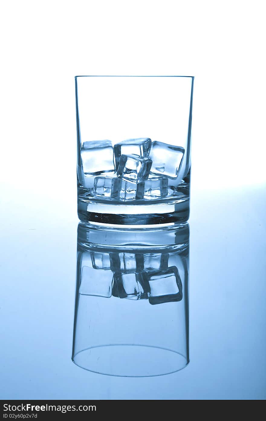 Glass of ice on white-blue background