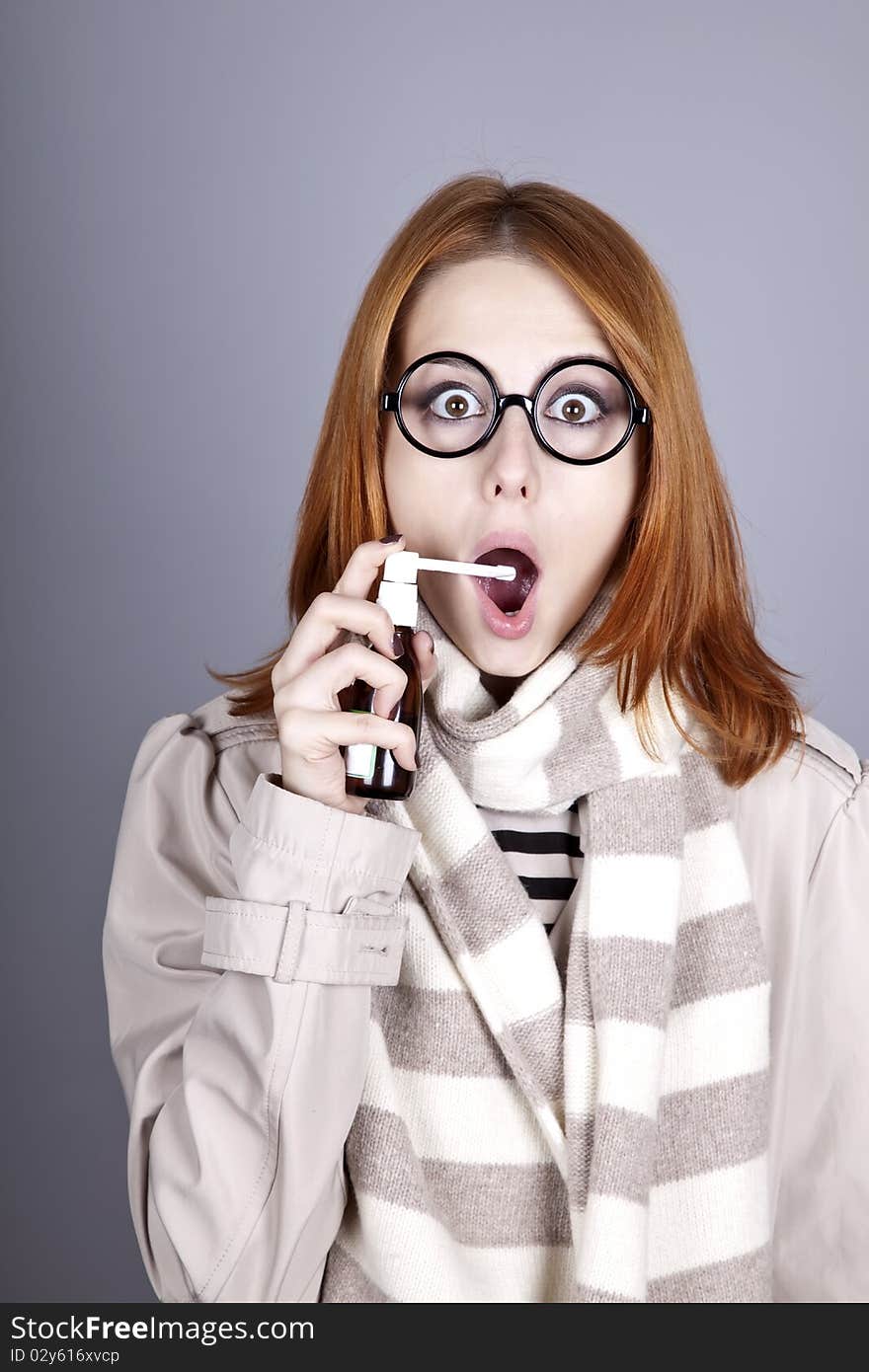 Chill red-haired girl in glasses with spray.