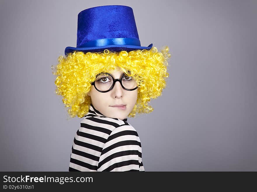 Portrait of yellow-haired girl in blue cap and striped knitted jacket. Studio shot.