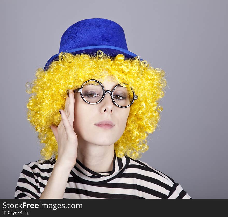 Portrait of yellow-haired girl in blue cap and striped knitted jacket. Studio shot.