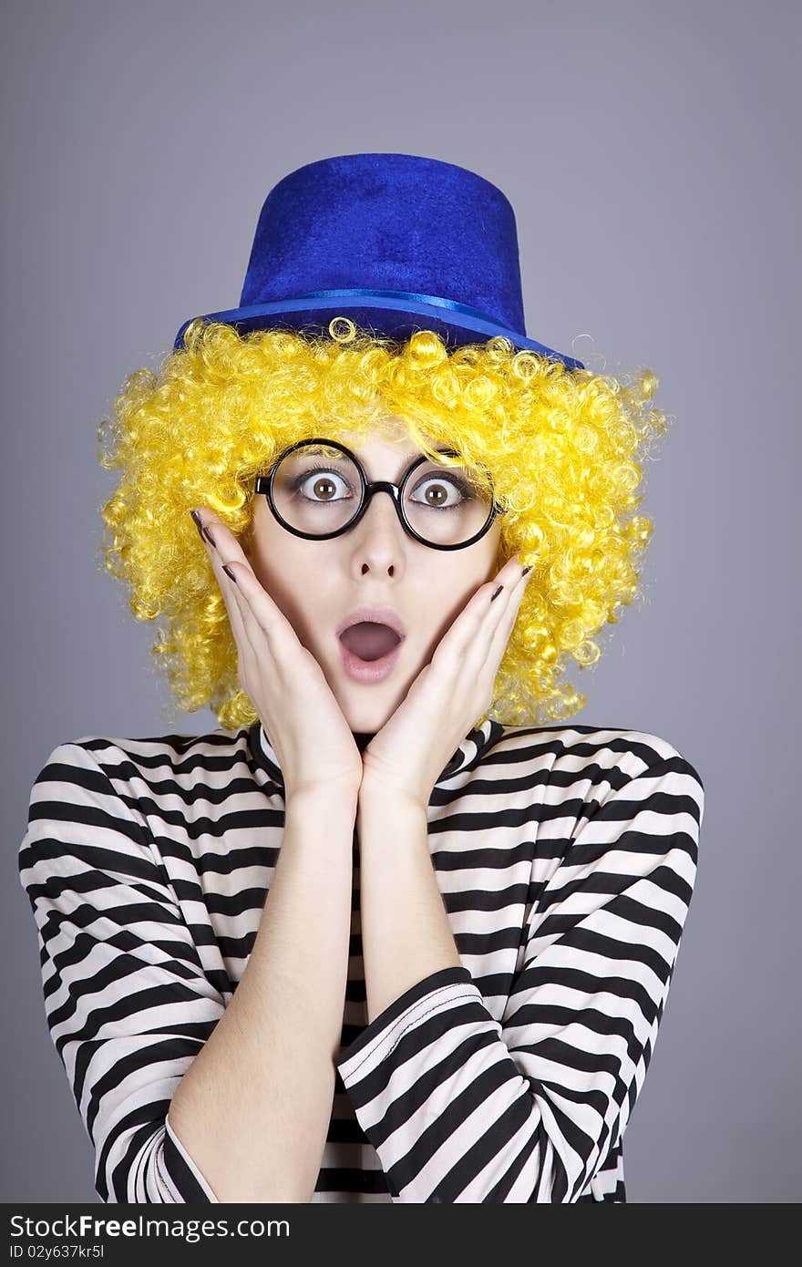 Portrait of yellow-haired girl in blue cap and striped knitted jacket. Studio shot.