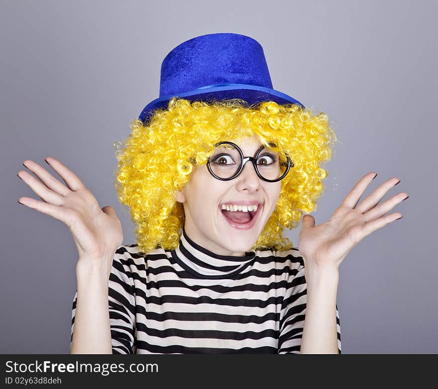 Portrait of happy yellow-haired girl in blue cap and striped knitted jacket. Studio shot.