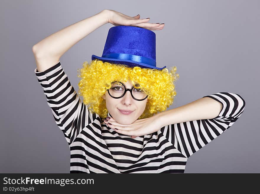 Portrait of yellow-haired girl in blue cap and striped knitted jacket. Studio shot.