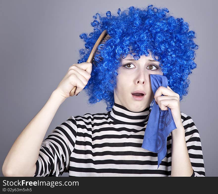 Portrait of sad girl with blue hair and comb. Studio shot.