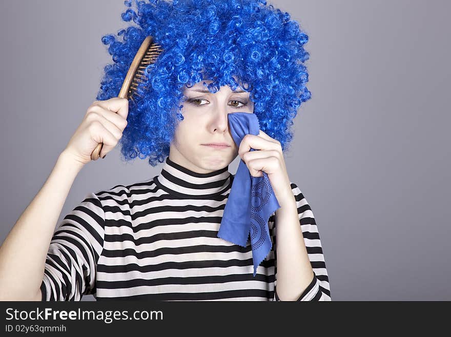 Portrait of sad girl with blue hair and comb. Studio shot.