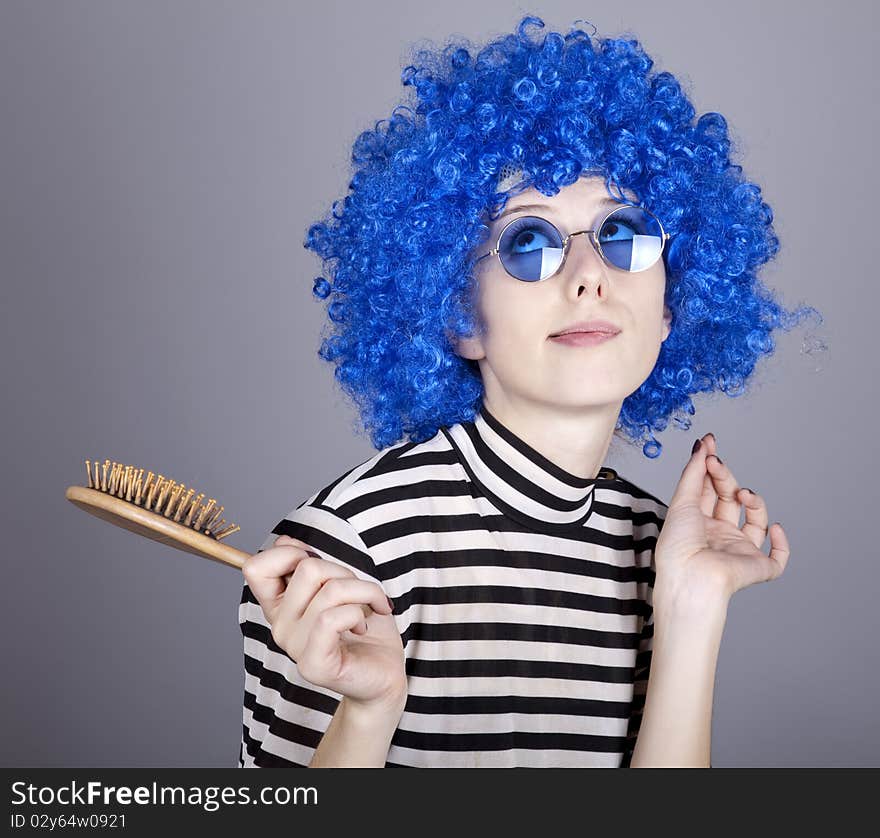 Coquette blue-hair girl with comb. Studio shot.