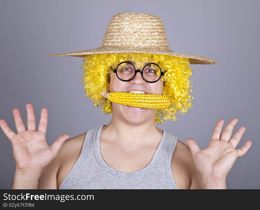 Funny farmer keep corn in mouth. Studio shot.